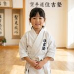 真新しい道着を着て笑顔で立つ小学生の女の子（札幌・空手道住吉塾）